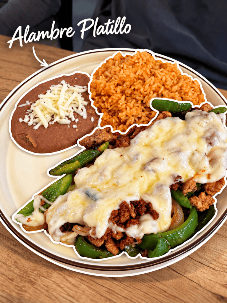 A plate featuring Alambre Platillo with grilled meat, peppers, and melted cheese, accompanied by refried beans topped with cheese and a serving of orange rice.