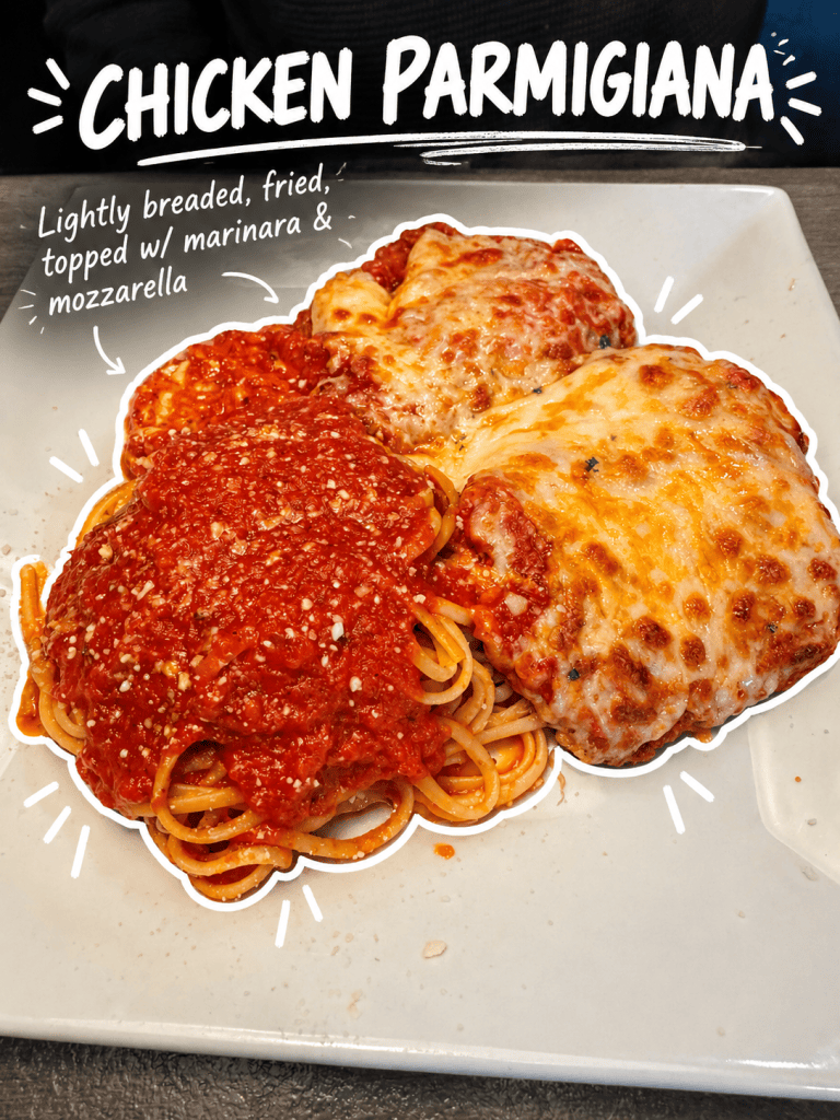 A plate of Chicken Parmigiana, featuring lightly breaded and fried chicken topped with marinara sauce and melted mozzarella cheese, served alongside spaghetti with marinara sauce.