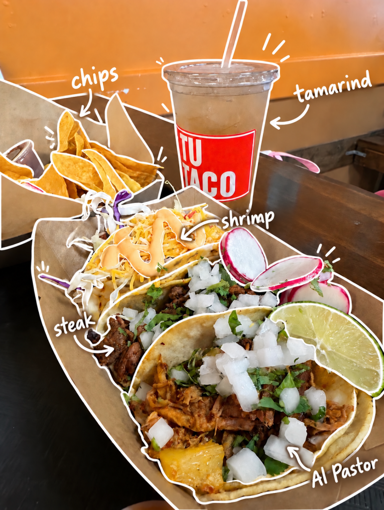 A serving of tacos featuring steak, shrimp, and al pastor, topped with onions and cilantro, accompanied by tortilla chips and a tamarind drink.